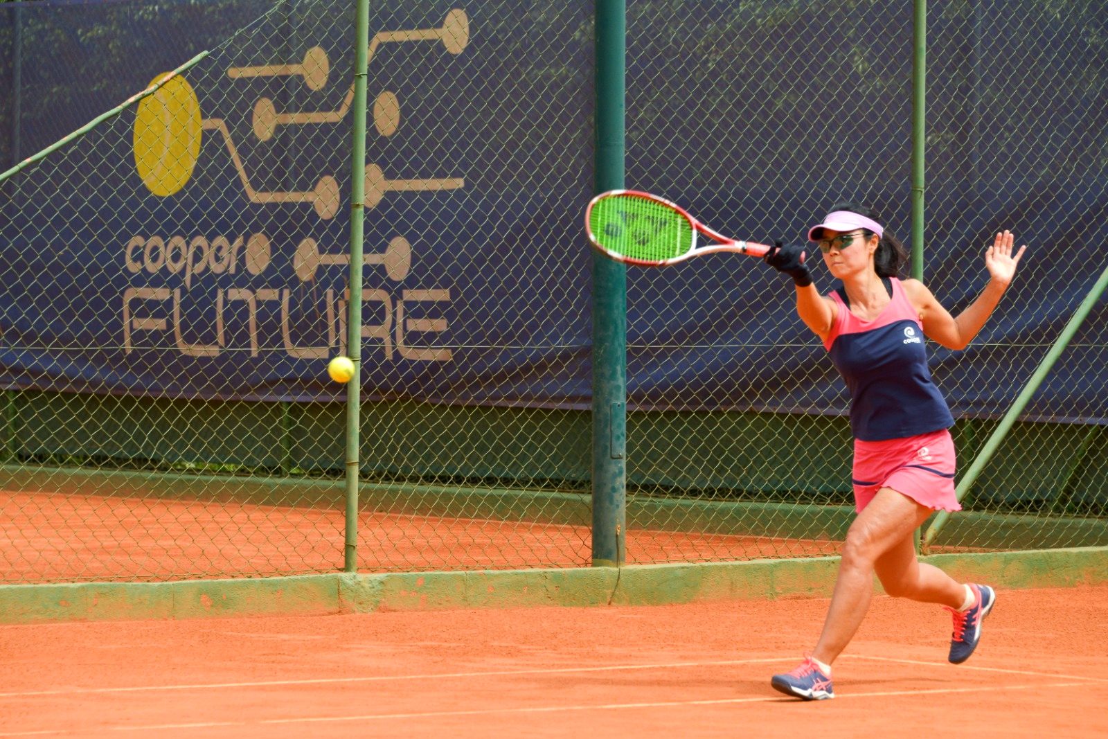Sócia executa um forehand no saibro